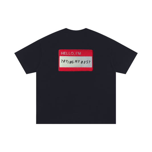 Black graphic T-shirt with “Hello, I’m trying my best” name badge patch – Garms.House