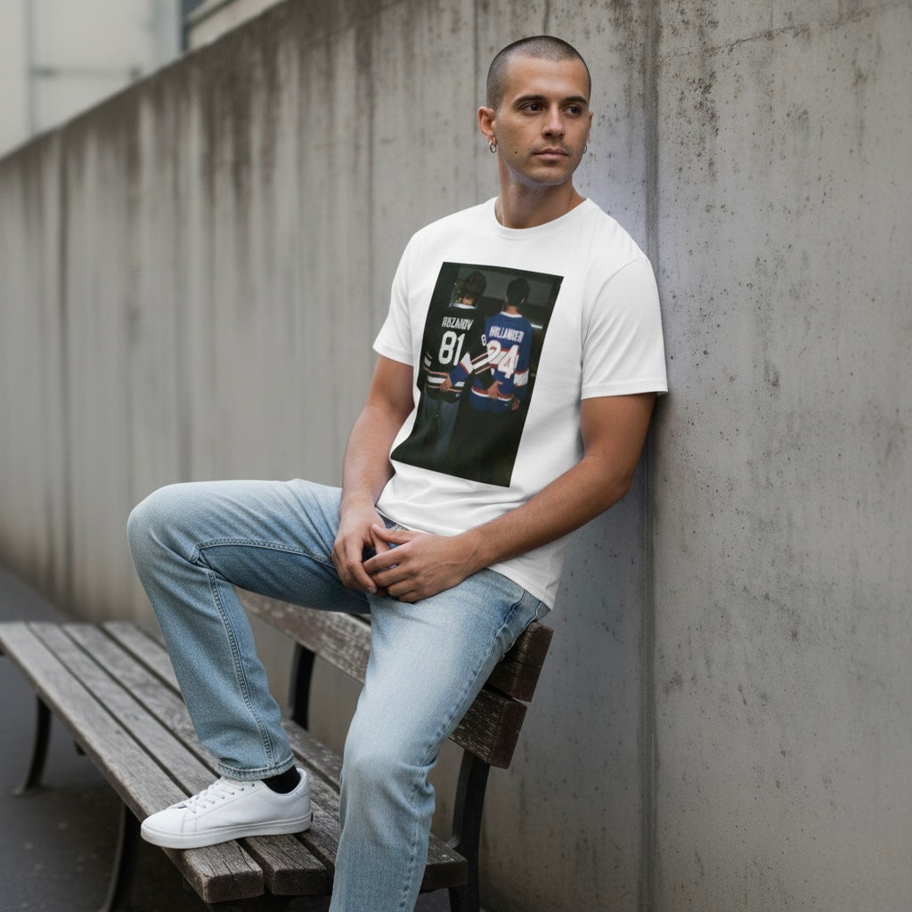 Man wearing a white unisex graphic t-shirt featuring a hockey rivalry inspired print with two players standing side by side, oversized fit.