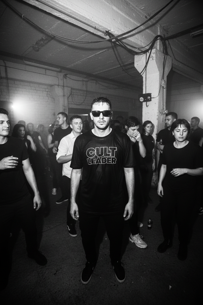 Man at warehouse techno rave in black and white wearing Cult Leader Outline tee with edgy sunglasses
